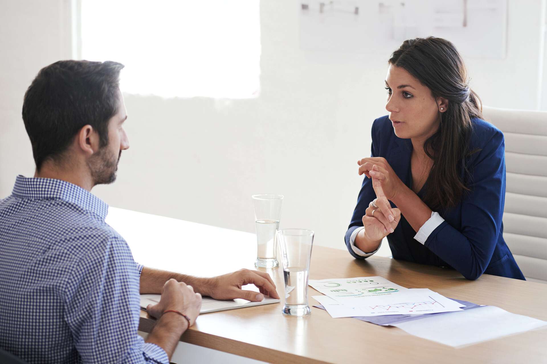 Mann und Frau in einem lichtdurchfluteten Büroraum am Tisch beim Gespräch. - Beschreibung iStock/Gettyimages: "What distinguishes you from all the other candidates? Model and Property Released (MR&PR) " #RLNCH_XXIII