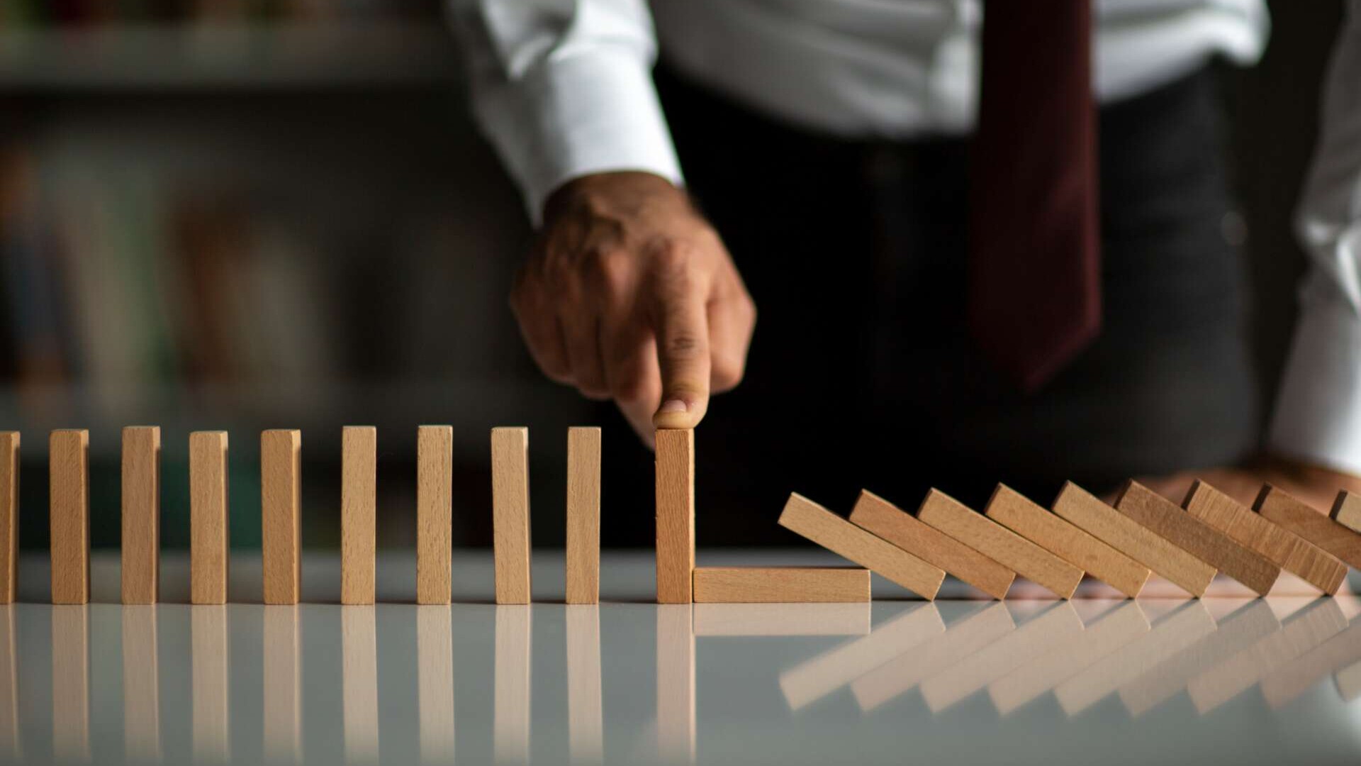 Geschäftsmann stoppt Domino-Effekt