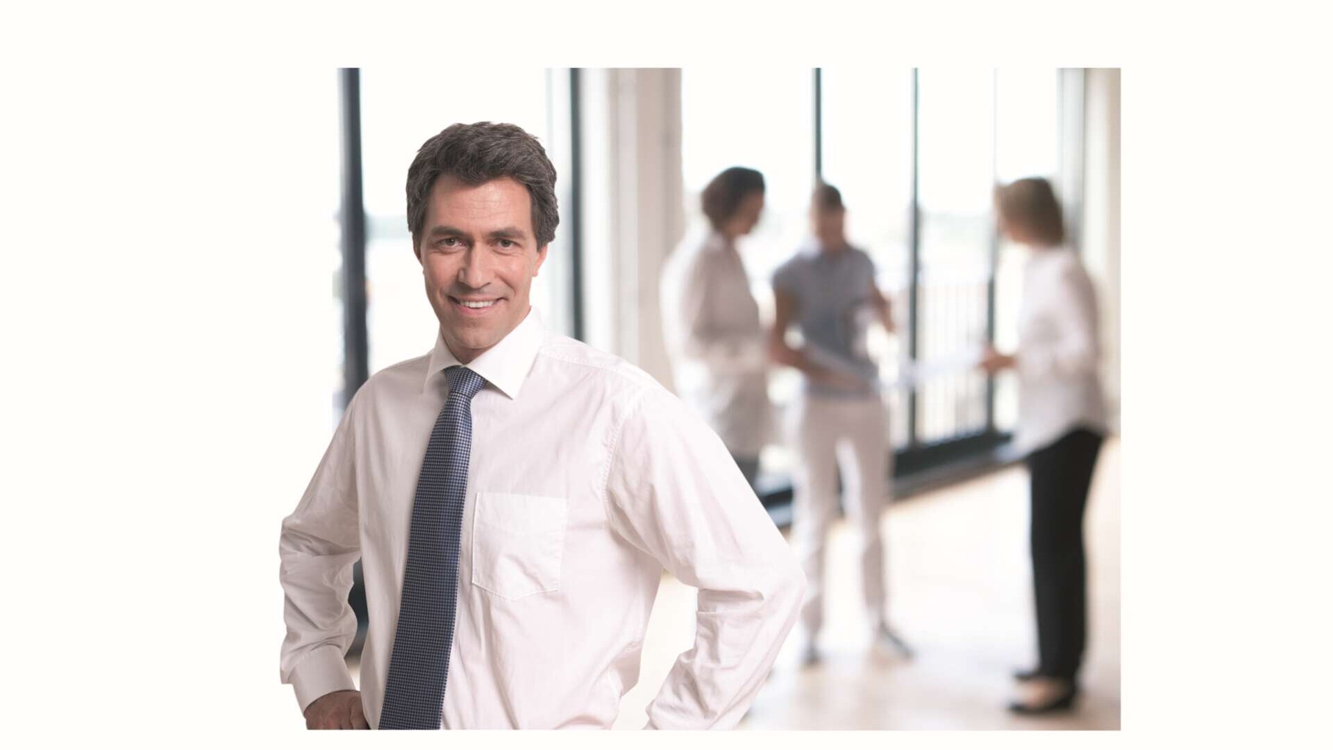 Mann mittleren Alters steht im Büro 