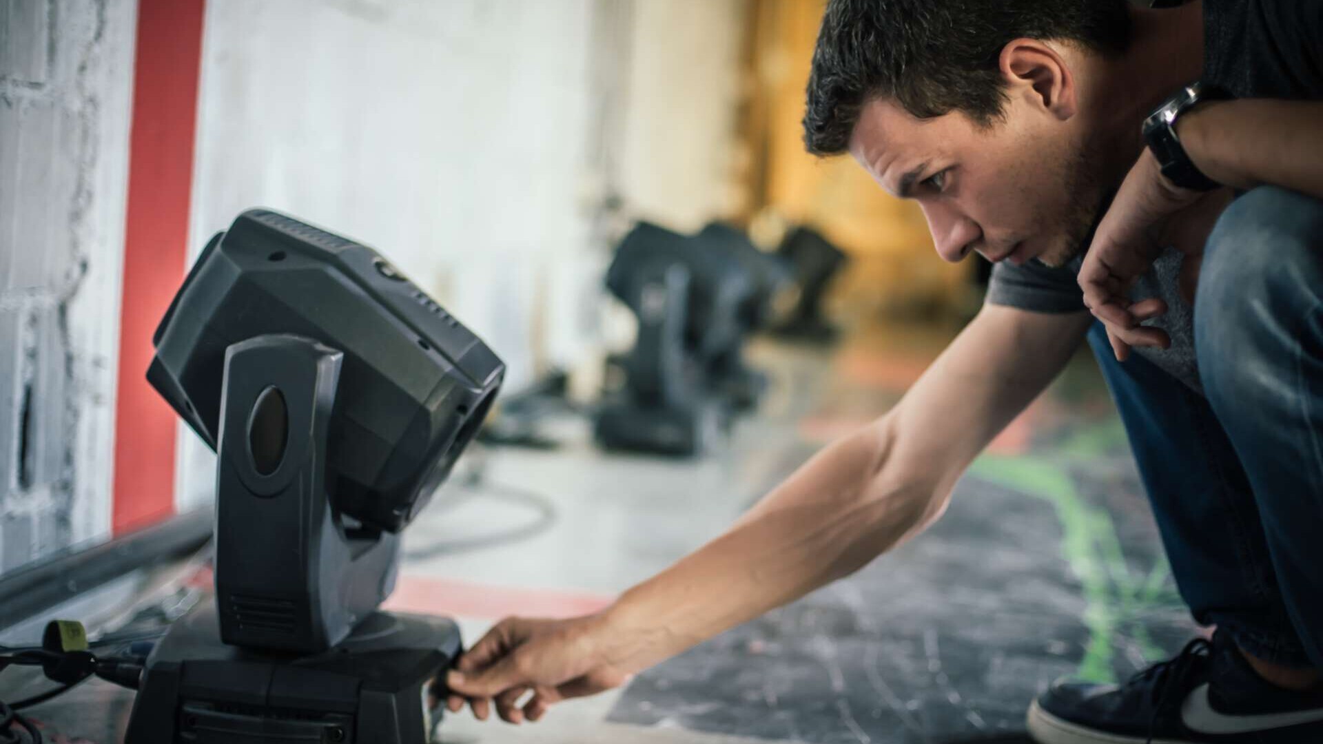 Theaterbeleuchtungstechniker, Elektroingenieur, der den Fokus der Beleuchtungselemente hinter der Bühne anpasst. Scheinwerfer im Theater. Hinter den Kulissen.#RLNCH_XXIII