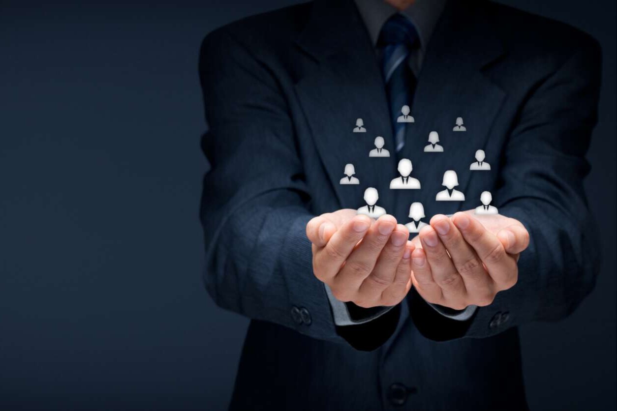 Hände schützend um zahlreiche Avatare